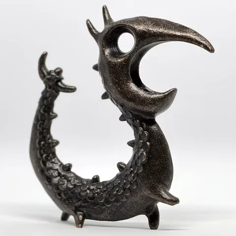 The cast-metal Dragon Opener standing against a pale background.