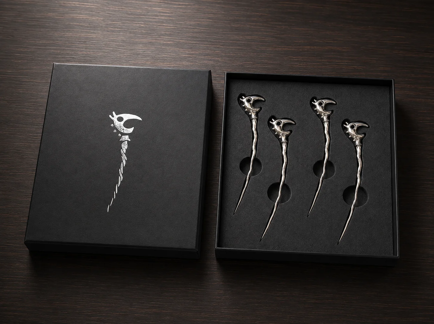 The finished Dragon Picks set: a black presentation-box lid beside four chrome picks in a fitted insert.