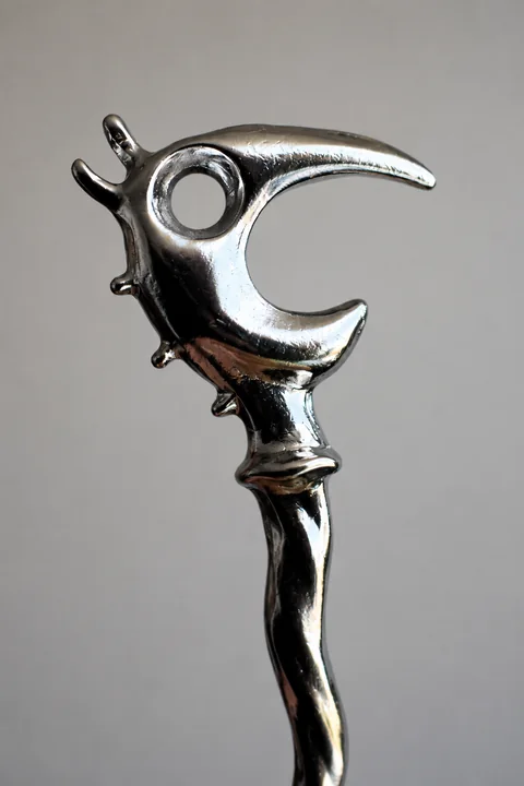 Close-up of the chrome Dragon Pick head against gray.