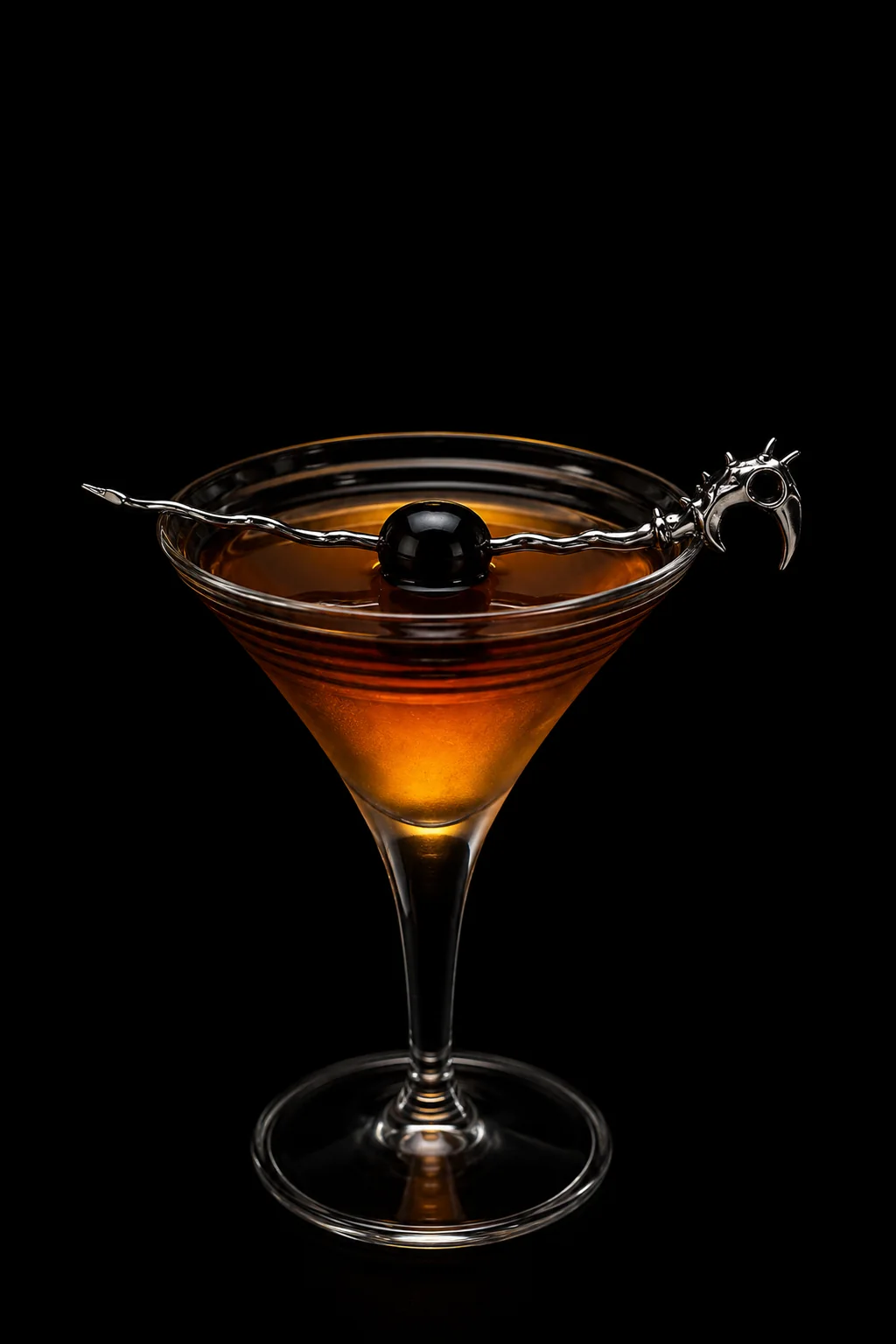 A polished Dragon Pick spanning an amber cocktail against black.