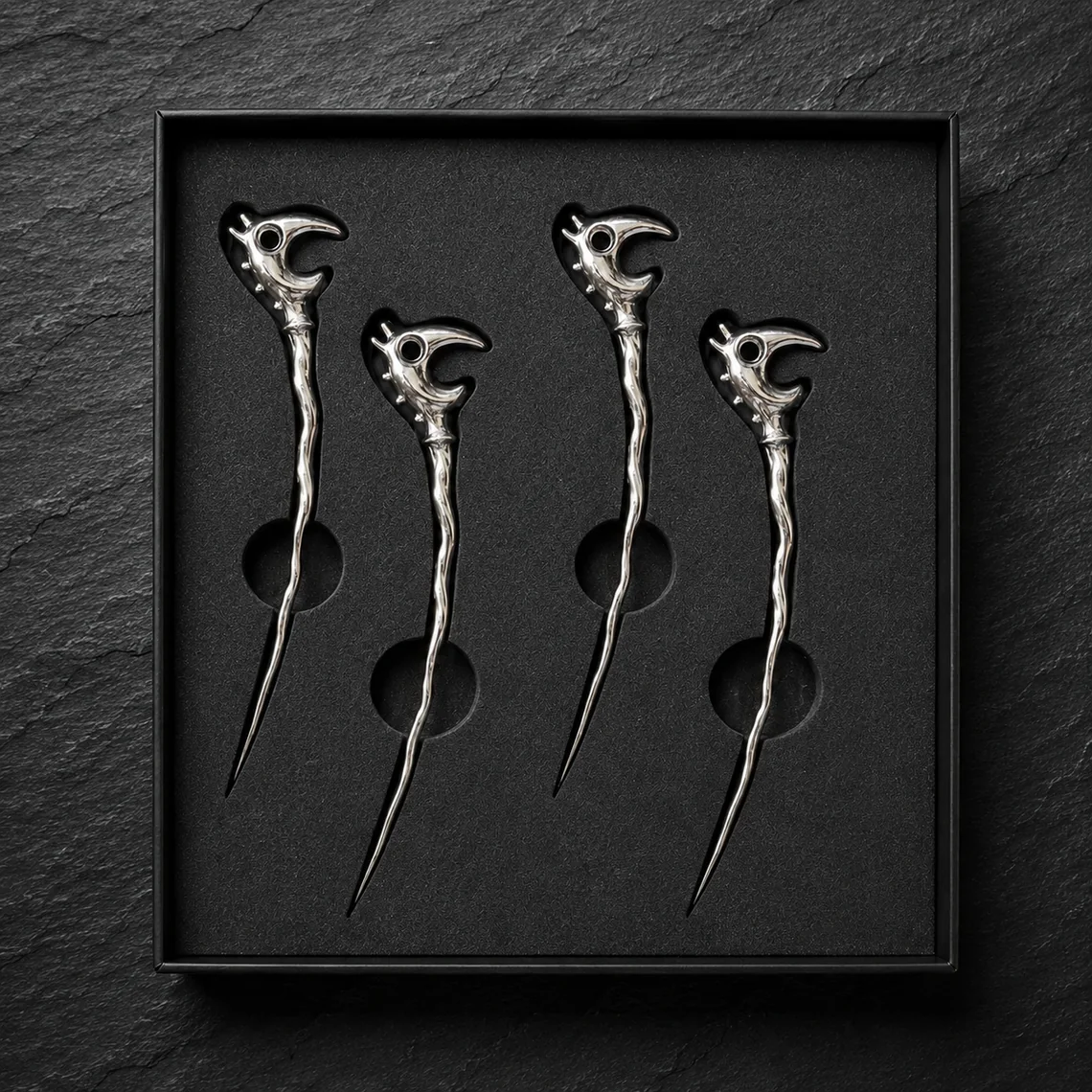 Four chrome Dragon Picks nestled in their black presentation box.